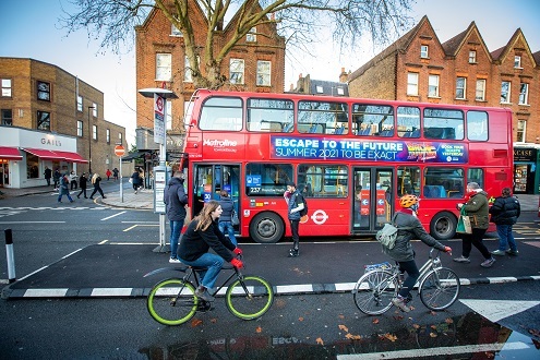 Cyclists in road by London bus