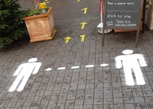 Social distancing stencil outside cafe in park