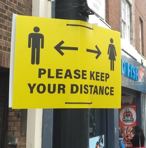 Keep your distance yellow street signage