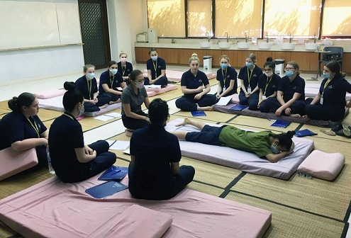 Students learning about Thai massage in a class setting