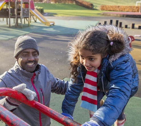 Foster care image of man with child in playground