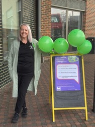 Sharon stood outside the venue smiling next to a poster for her event