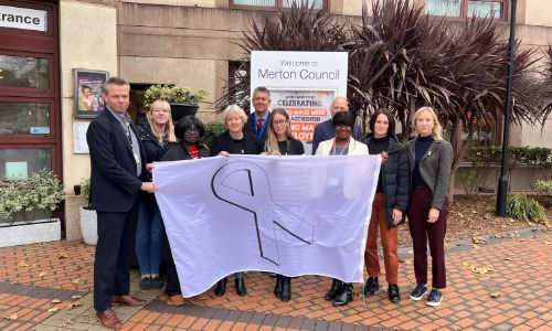 Council staff, partners and councillors hold the White Ribbon flag outside of Merton Civic Centre