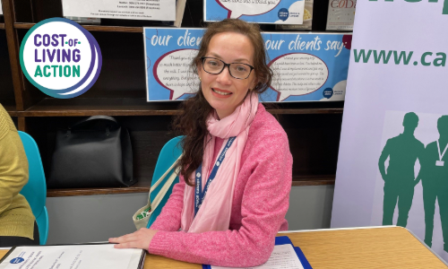 A support worker at a table smiling