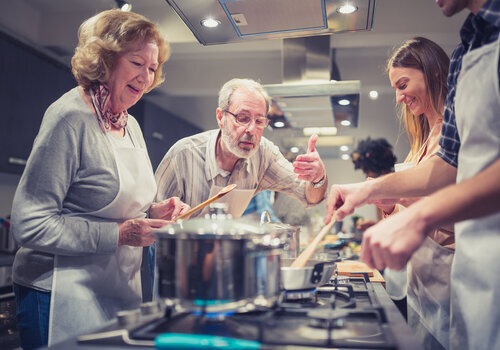 Group of people cooking together in kitchen setting