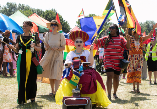 Mayor of Merton Cllr Gill Manly and other attendees waving Caribbean flags at Mitcham Carnival 2023