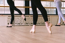 Dancers legs in a ballet studio wearing ballet shoes 