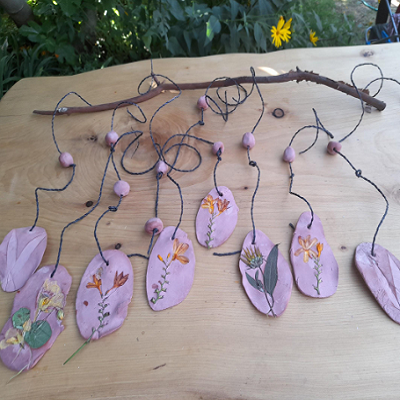 clay pieces with flowers stuck in them on a piece of wood
