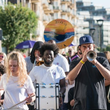 Brass Band marching with crowd following behind