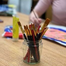 Glass jar with paint brushes in