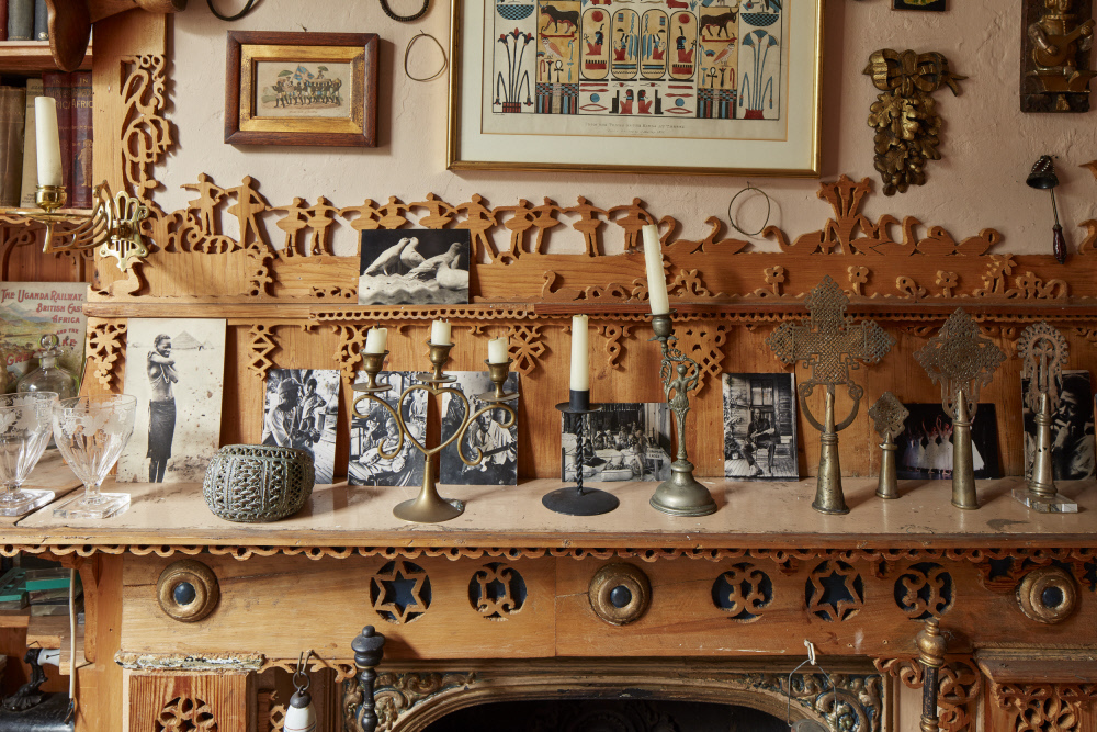 An Image Of A Mantel Piece of Photo's From 575 Wandsworth Road- The Home Of Khadambi Asalache, A Kenyan-born Artist, Poet And Civil Servant