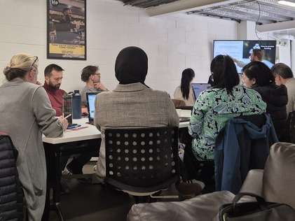 People sitting at a table listening to a presentation