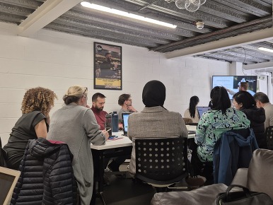 People sitting at a table listening to a presentation