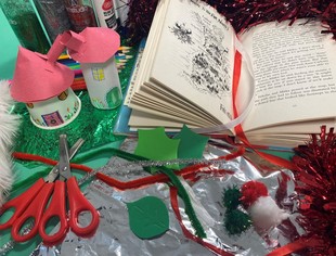 Two elf dwellings made of card stood next to a copy of Matt Haig's A Boy Called Christmas
