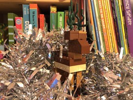 A reindeer made of Lego nestled in tinsel
