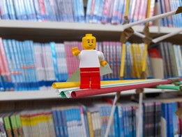 A Lego mini-figure in front of a bookcase