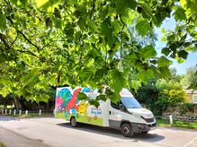 A story bus surrounded by green leaves