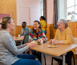 People talking at a table with hot drinks