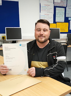 Male learner holding certificate