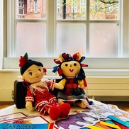 Two Spanish style dolls sat in front of a window