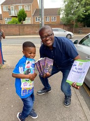 Man and child holding copies of Harry Potter books and Peppa Pig magazines.