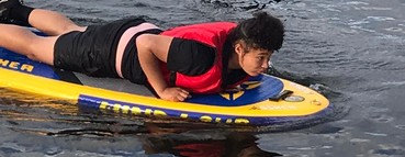 Boy lying on waterboard