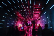 people dancing under a purple light in a dark room