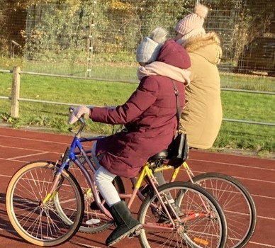 Two  people on an adapted bike in winter clothes
