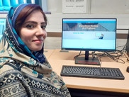 A learner sitting by a computer looking proud of themselves