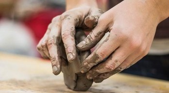 A pair of hands playing with clay