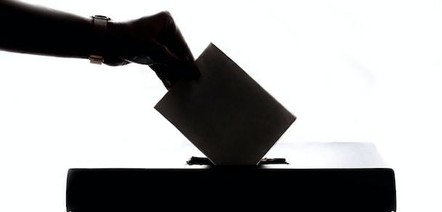 Hand placing vote in a box