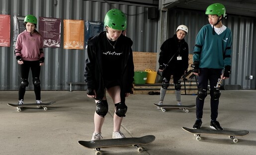 Young people having skateboarding lesson