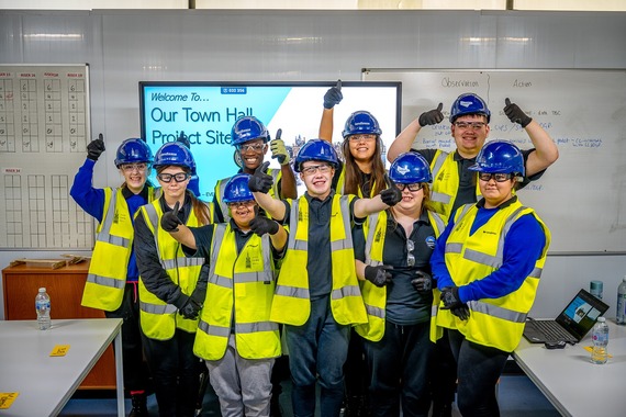 Image shows a group of students from Northridge School in north Manchester, in hi-vis jackets and safety helmets.