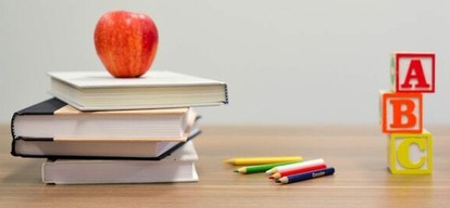 School items, including an apple on a pile of books