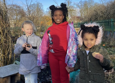 Group of children in winter clothes smiling in the MUD garden