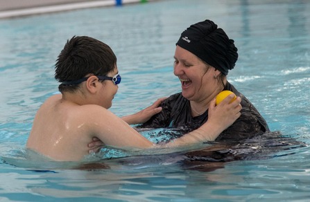 Mother and son swimming in pool