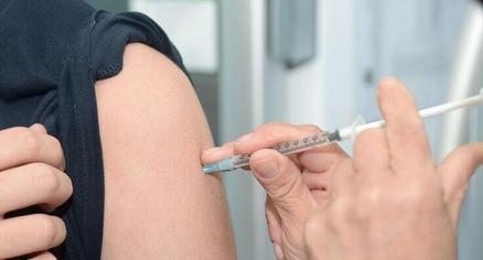 Vaccine being put into a woman's arm