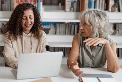 Two women sat at a table talking 