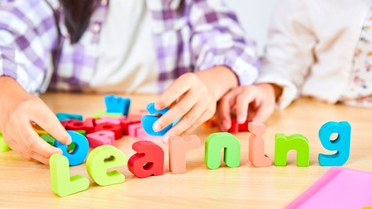 Young person spelling out the word 'Learning'