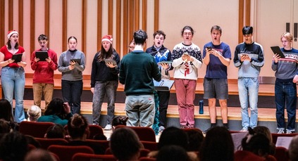 People standing on stage singing carols