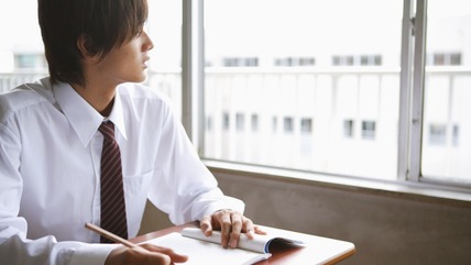 Young man looking anxiously out of window
