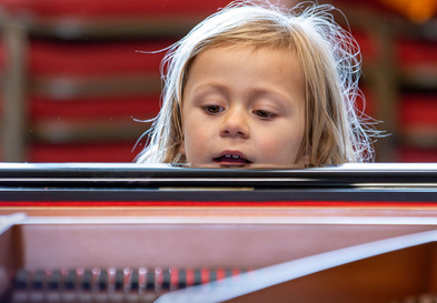 Girl looking out over piano