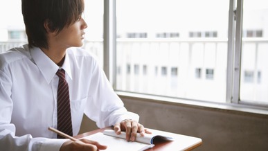 Young pupil looking out of classroom window