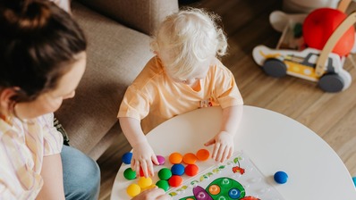 Young child playing with adult watching