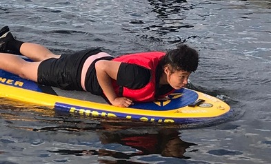 Boy lying on paddleboard