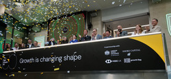 Image of people sat at a long table. In from of them is a sign that reads Growth is changing shape