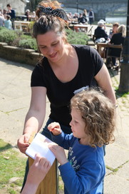 Little girl trying out the brass rubbing on the River Trail 