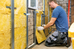 Man fitting wall insulation