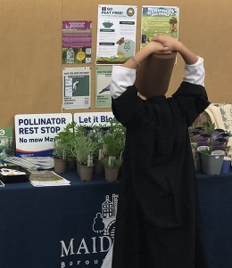 child in costume looking at information stand