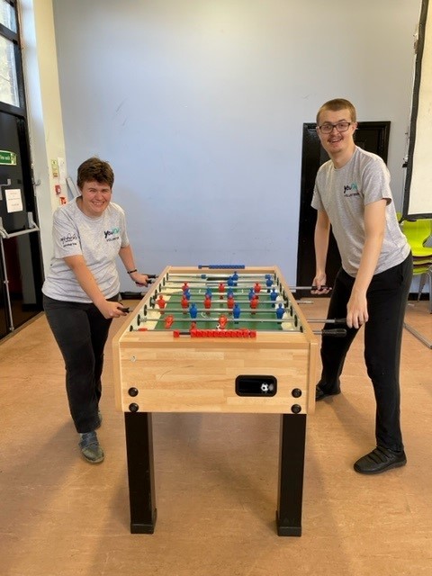 Two young people playing table football